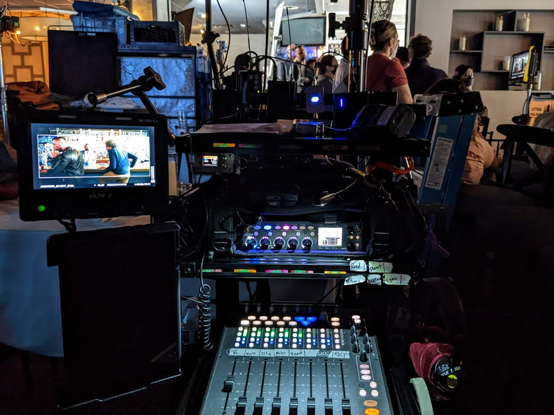 Feature sound cart is illuminated with monitor while large crew stands in the background
